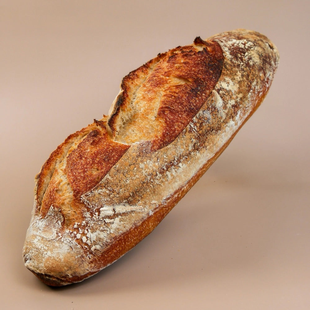 Atome sourdough loaf with a golden, flour-dusted crust