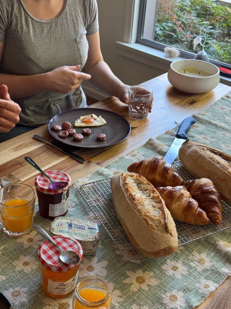 A weekend breakfast table with fresh croissants and bread