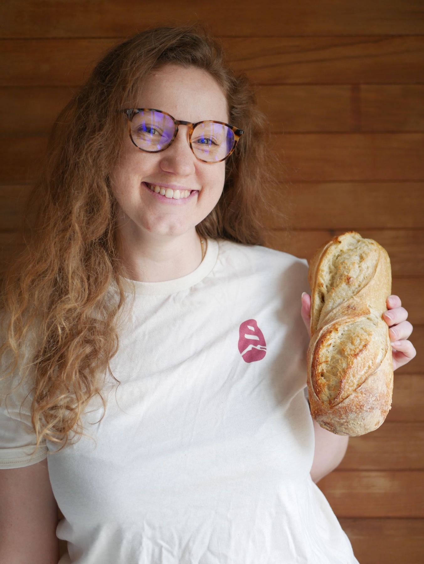 Alice Couderc, co-founder of Atome, smiling and holding a sourdough loaf