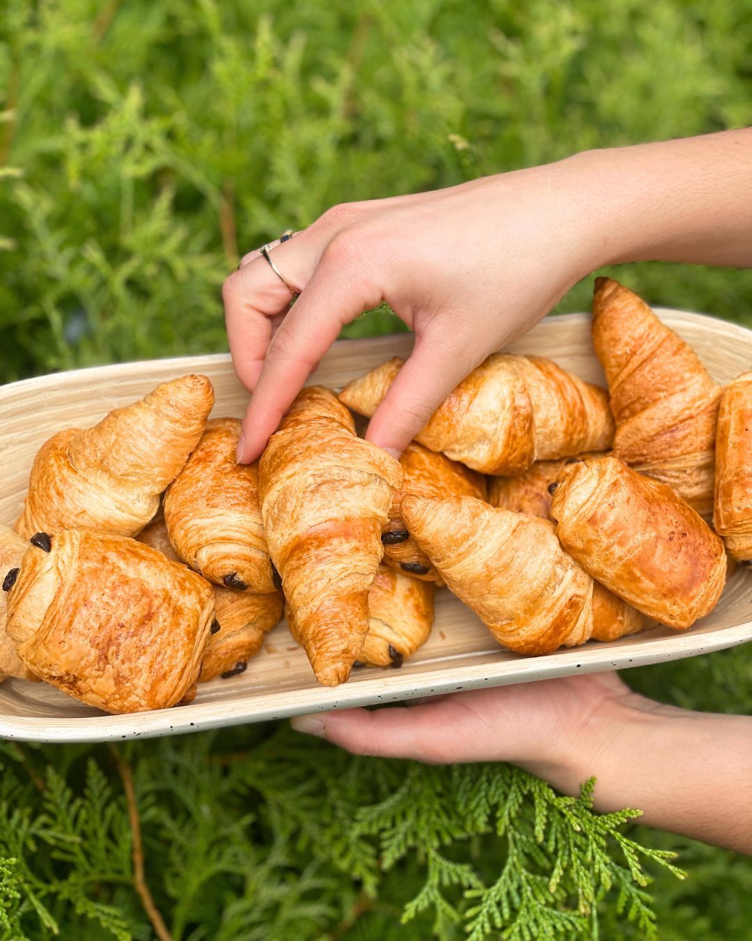 Hands reaching for mini croissants outdoors