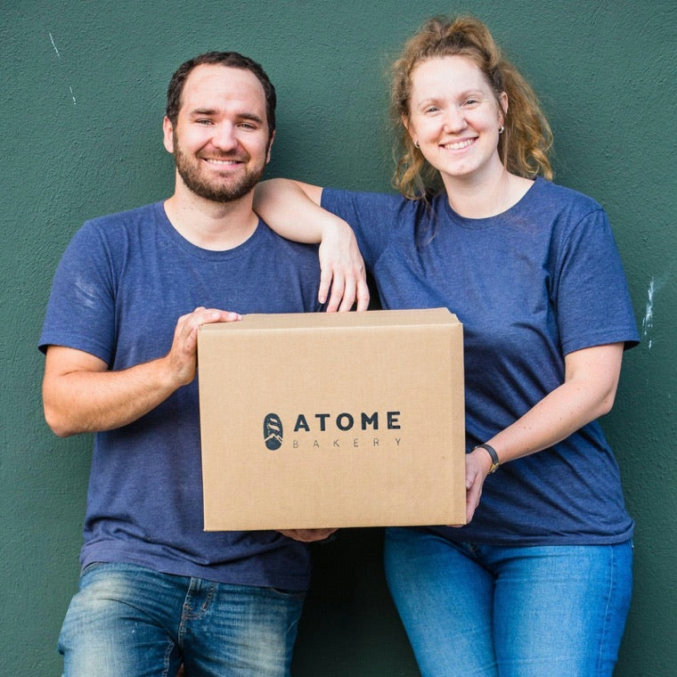 Alice and Lucas, the founders of Atome Bakery, holding an Atome box